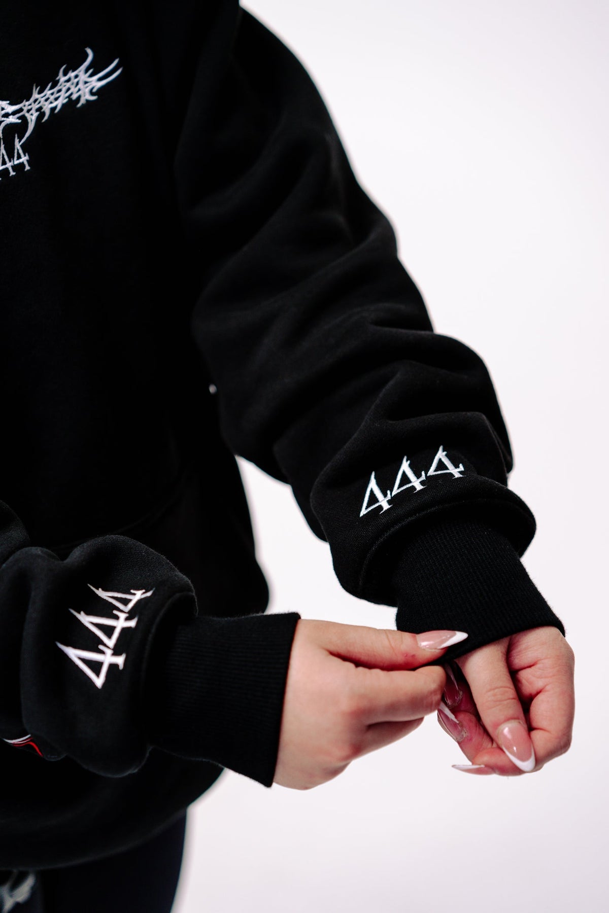 Black reflective hoodie with red tribal back graphic, worn by rider