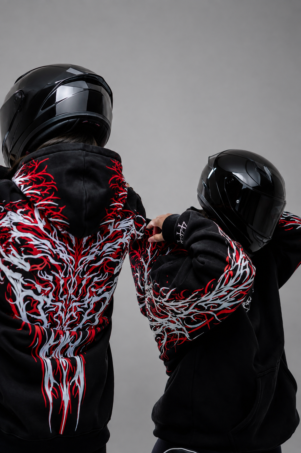 Black reflective hoodie with red tribal back graphic, worn by rider